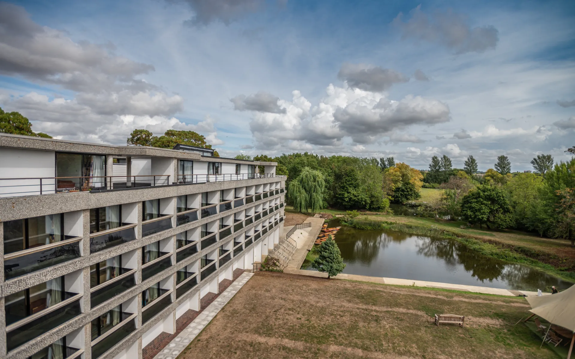 A building against a blue sky in front of a pond