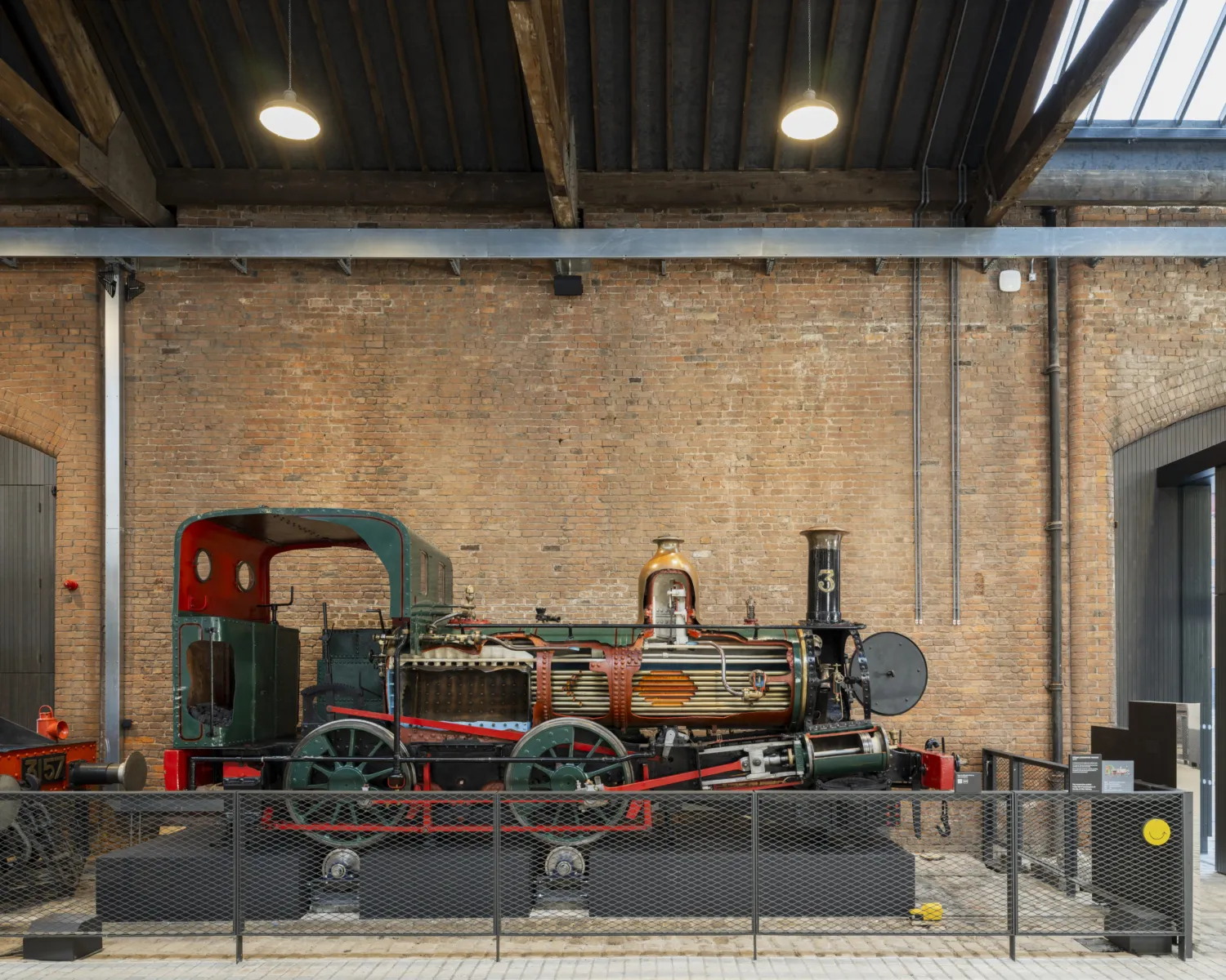 A locomotive engine which has been cut away in several areas to reveal the working parts inside, for example the steam cylinder, and the coal store.