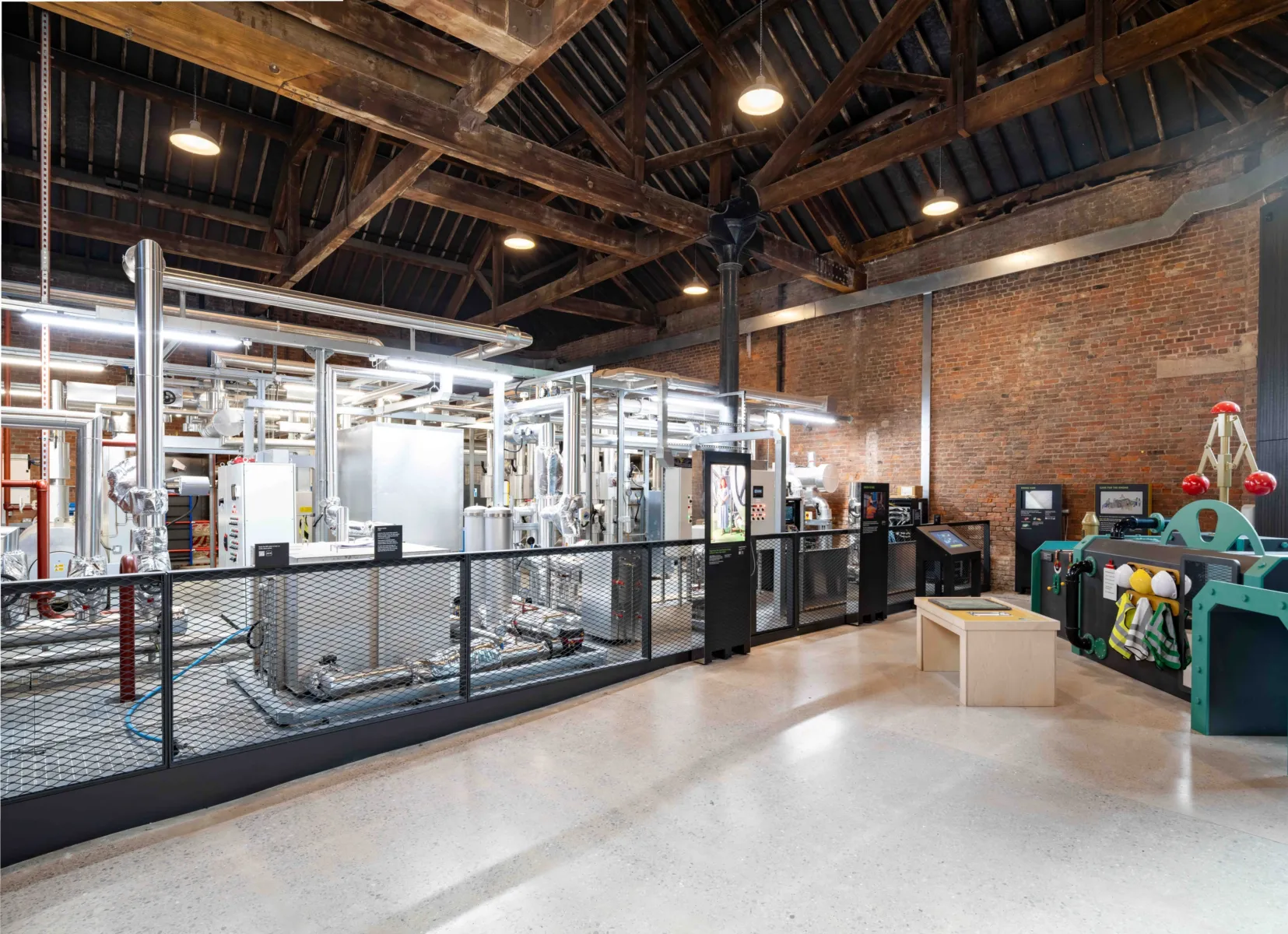 A photo showing the new electric steam system, an exposed system of silver coloured pipework, is on view in the museum alongside the vintage steam engines it powers.