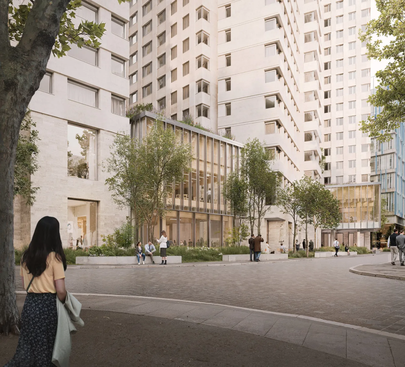 A pedestrian‑friendly urban courtyard framed by light‑coloured residential buildings, with trees, seating, and people walking, sitting, and socialising at ground level.