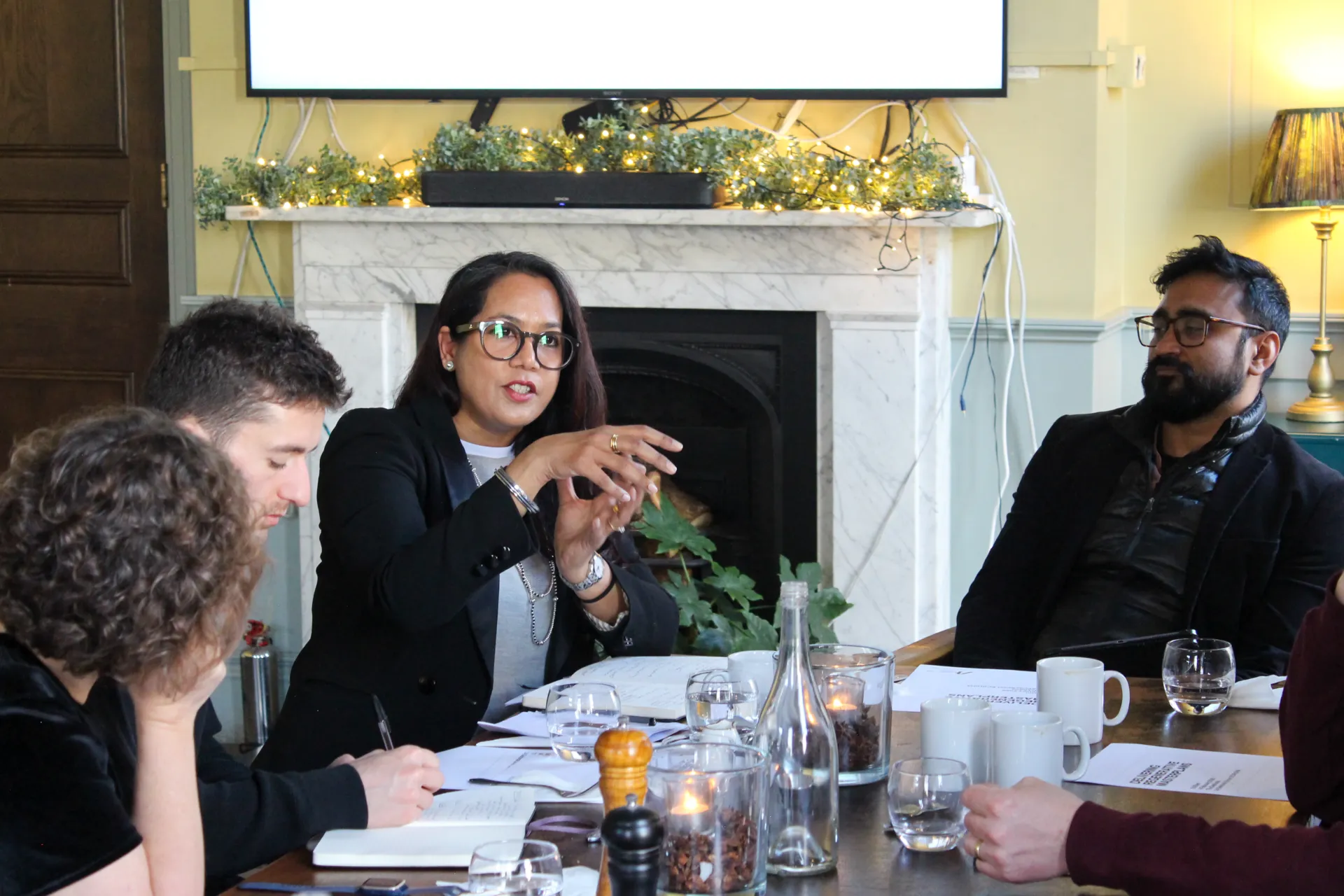 People sitting around a table in an elegant room having a conversation about masterplanning