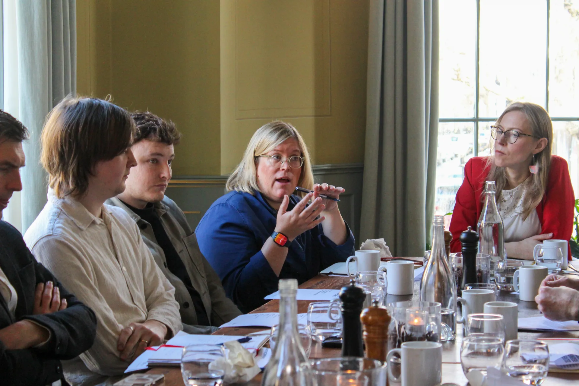 People sitting around a table in an elegant room having a conversation about masterplanning