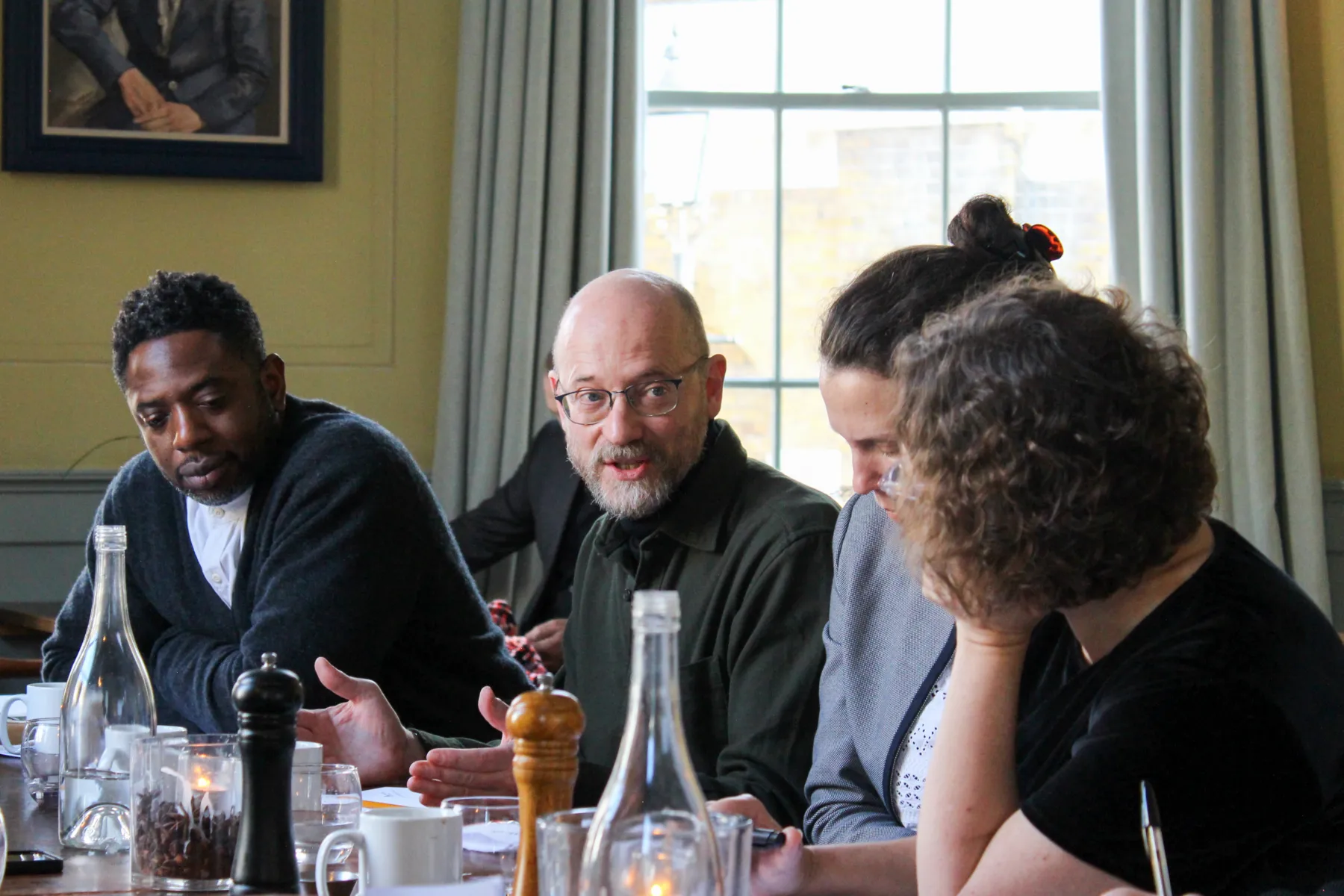 People sitting around a table in an elegant room having a conversation about masterplanning
