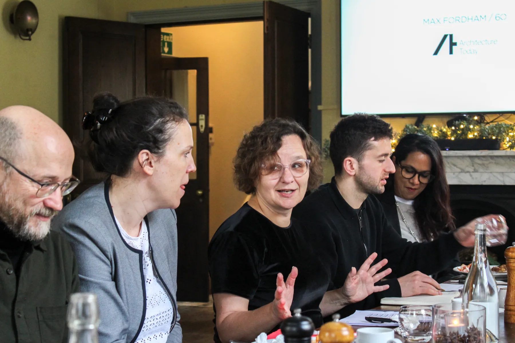 People sitting around a table in an elegant room having a conversation about masterplanning