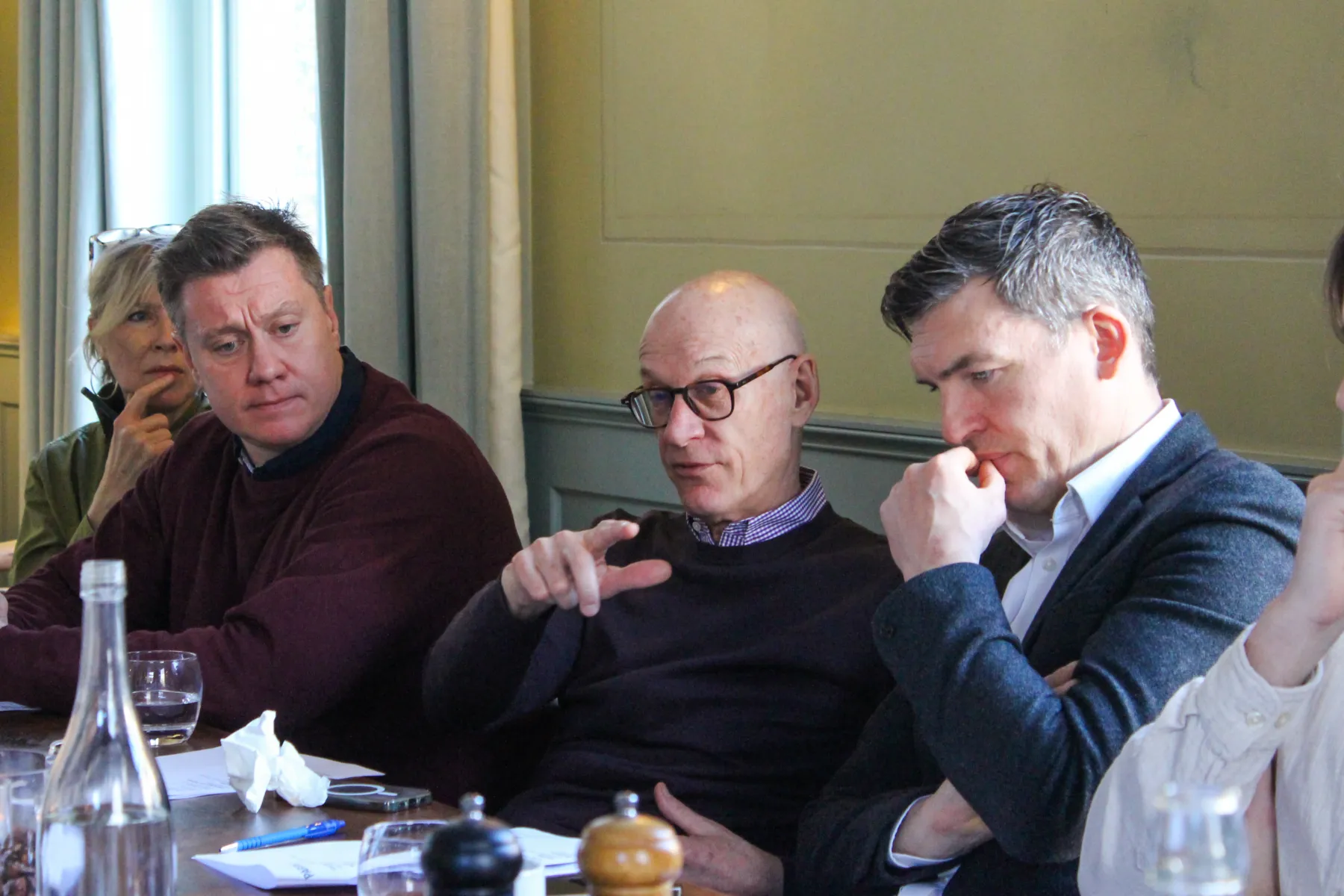 People sitting around a table in an elegant room having a conversation about masterplanning