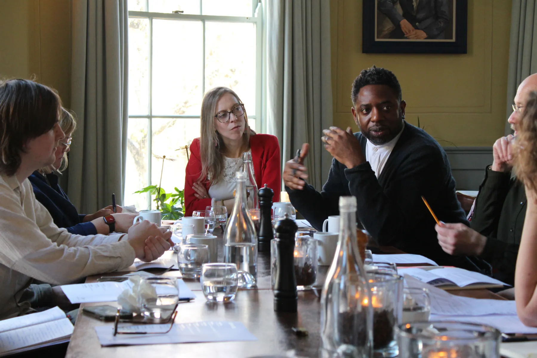 People sitting around a table in an elegant room having a conversation about masterplanning