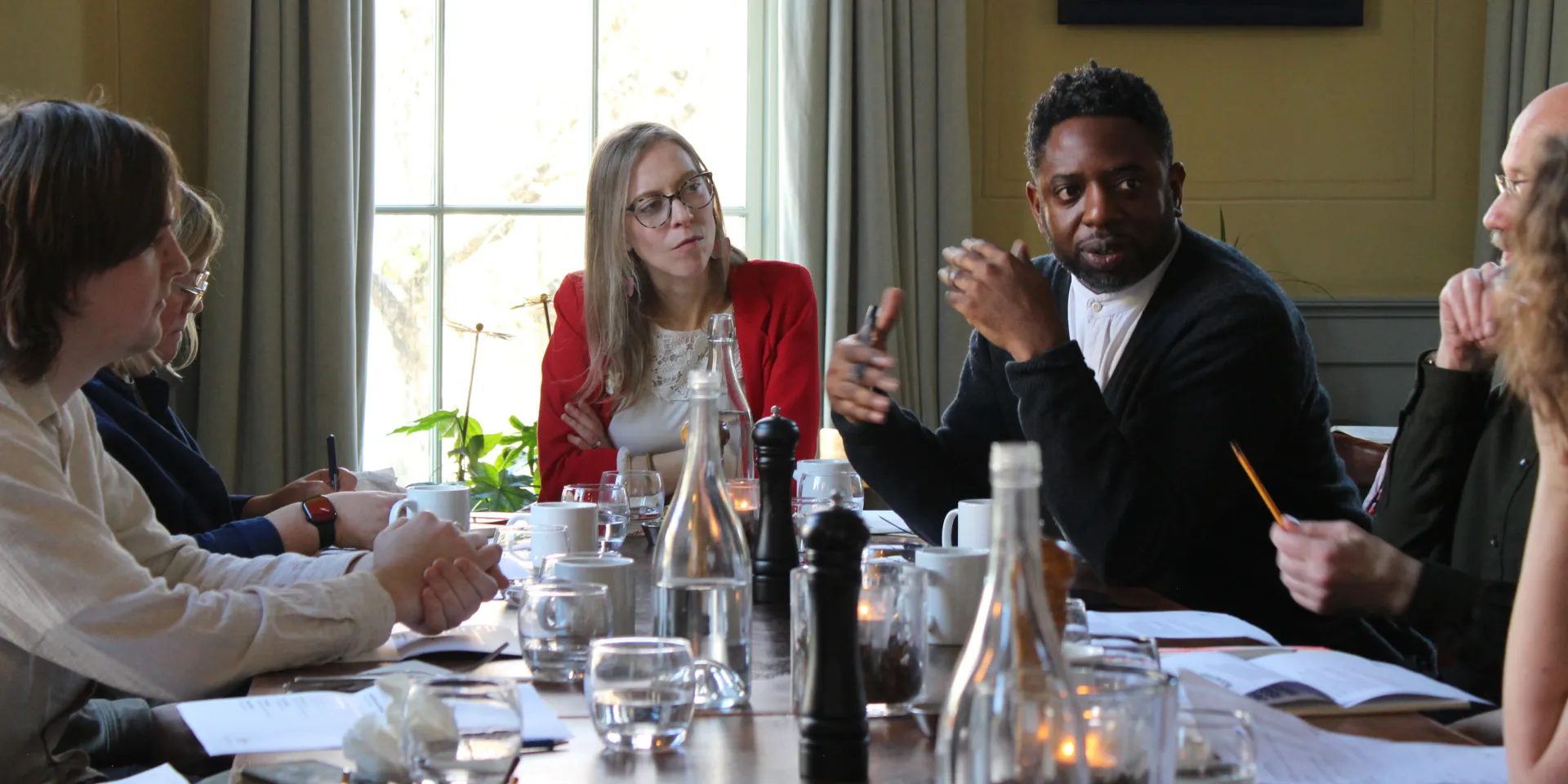 People sitting around a table in an elegant room having a conversation about masterplanning