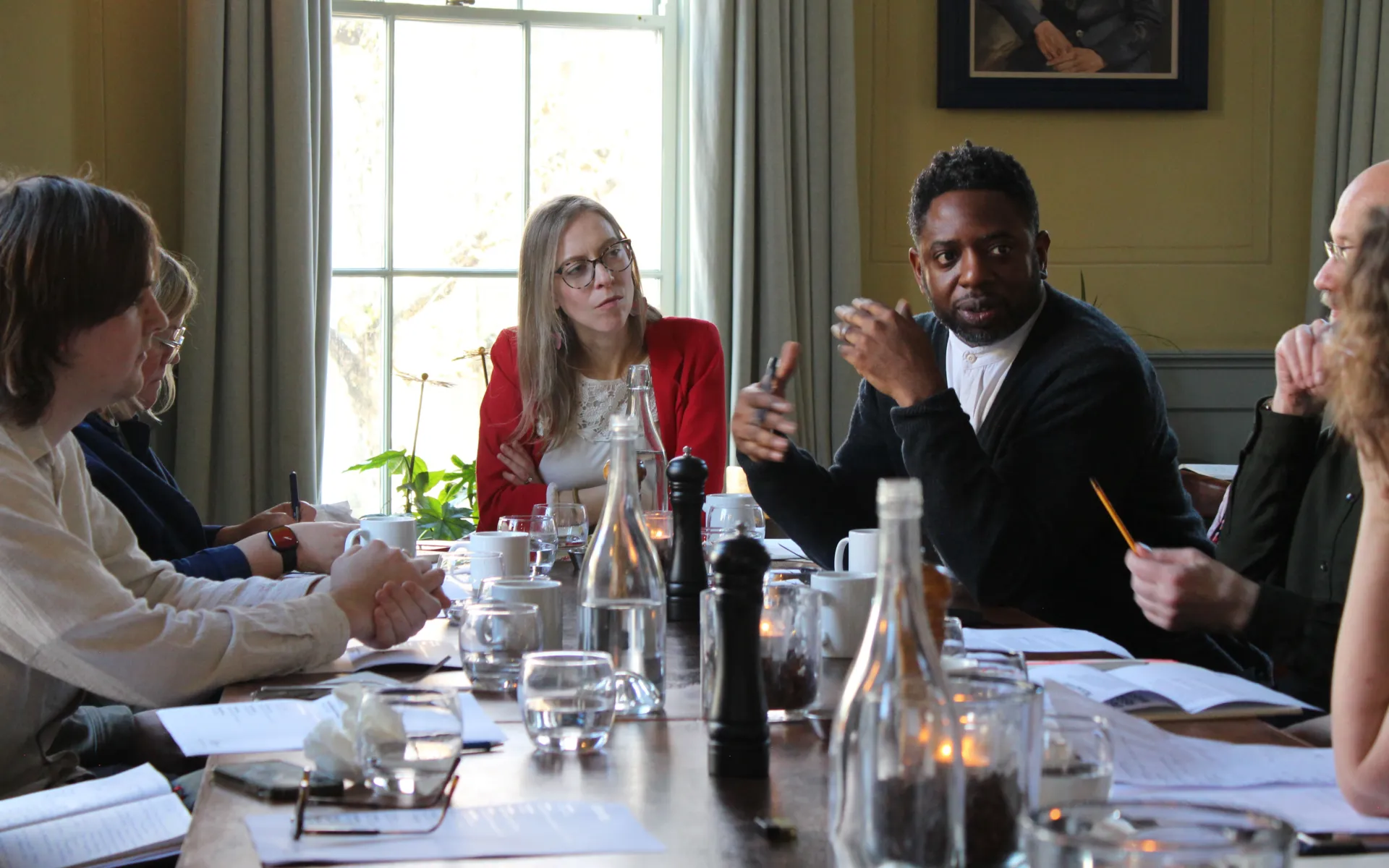 People sitting around a table in an elegant room having a conversation about masterplanning