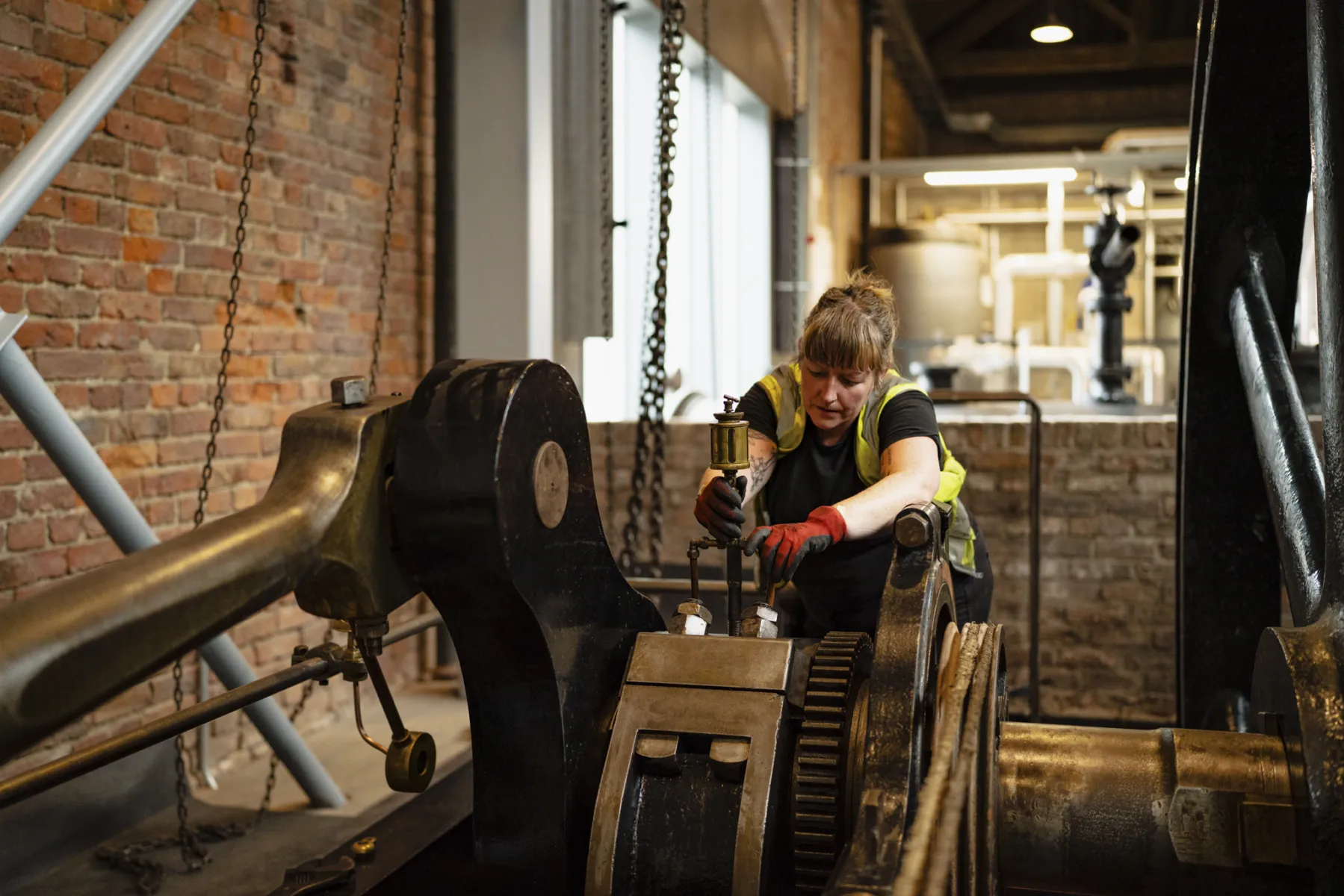 woman is pulling a lever on old machinery