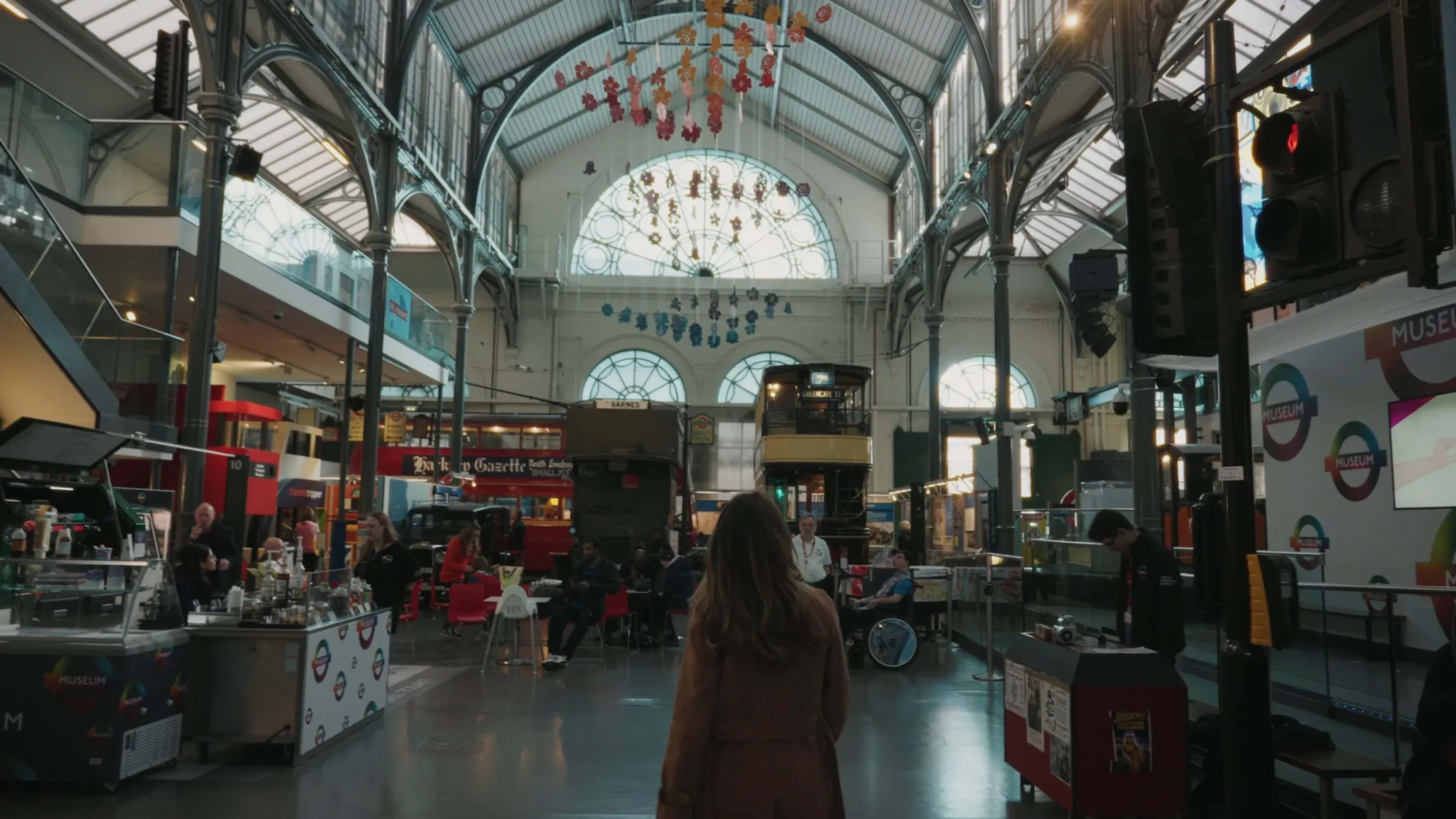 Imogen walking through London Transport Museum, surrounded by buses