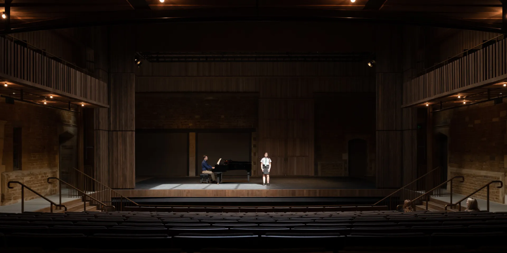 Photograph of young performer on stage at Nevill Holt Opera, accompanied by a pianist.