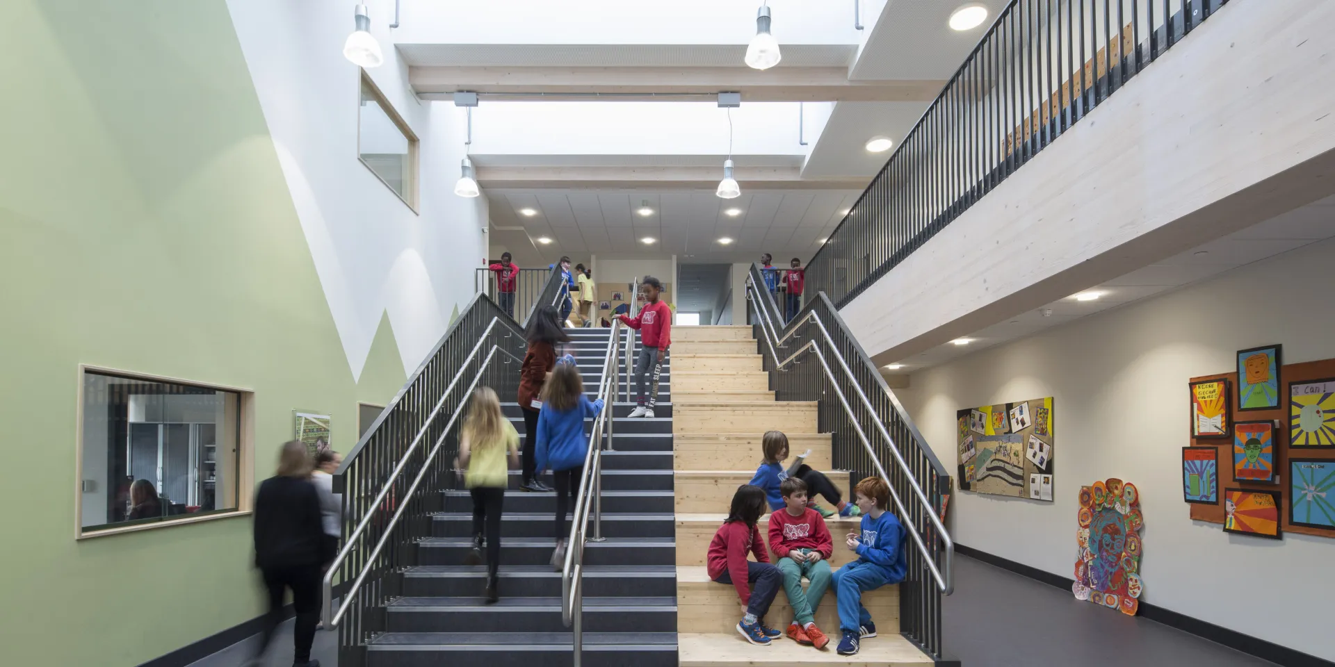 Kids sitting on and walking up and down stairs in a school
