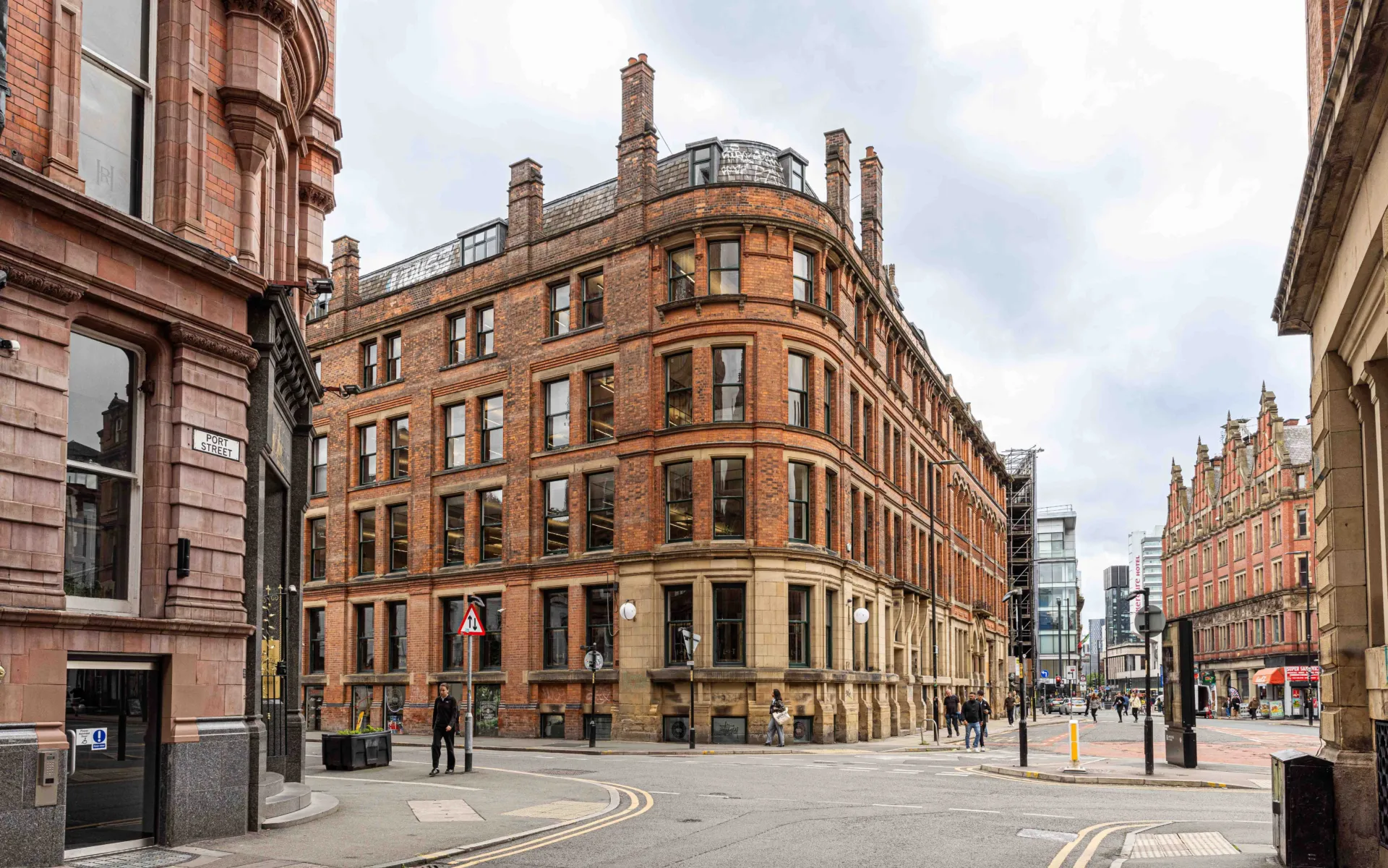 Photo of the outside of the Victorian Cottonopolis building, showing the surrounding streets and buildings.