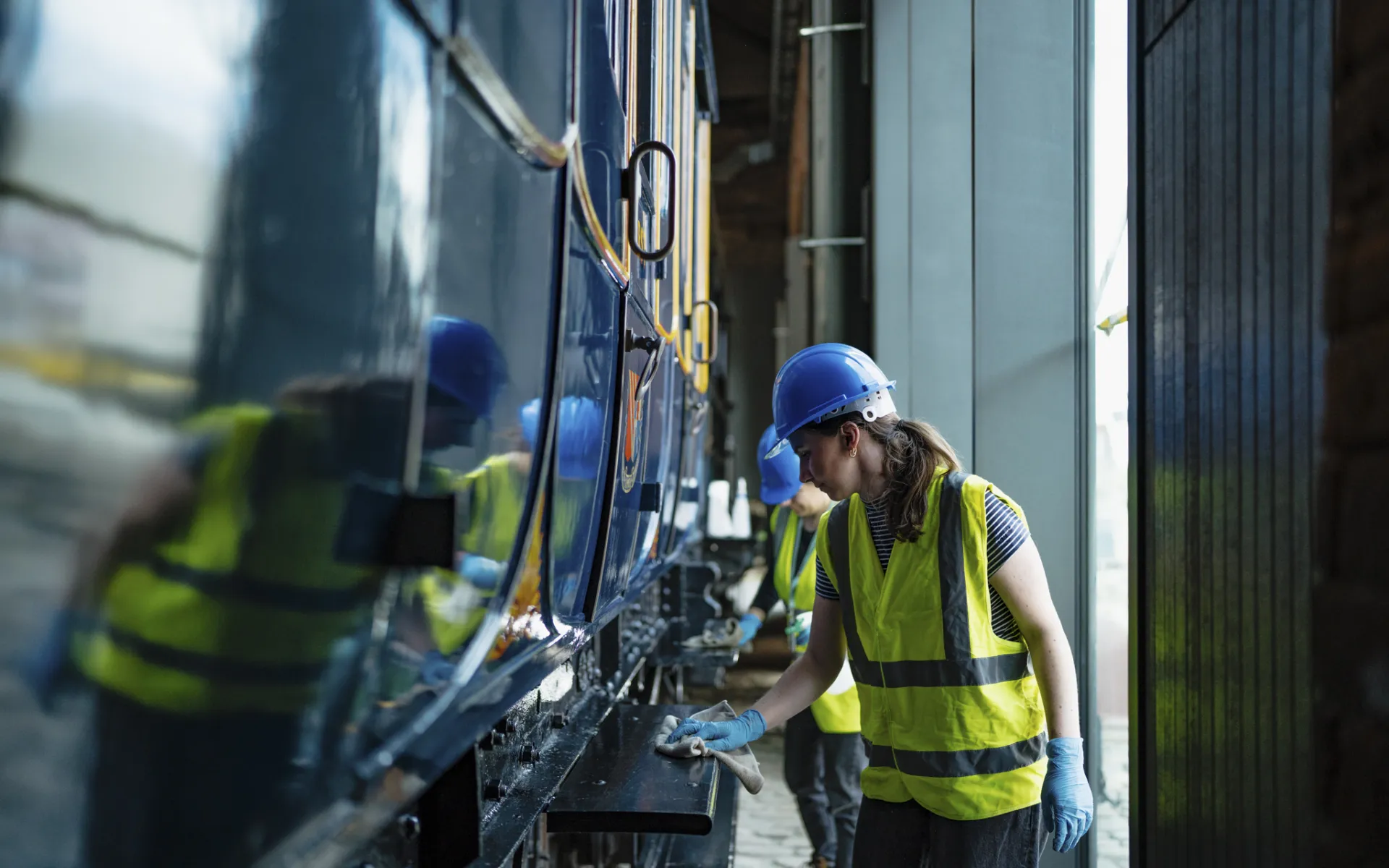 person cleaning an engine with a rag