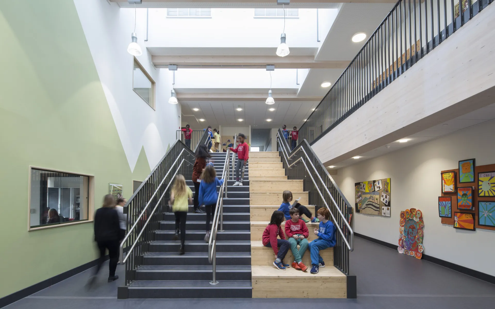 Kids sitting on and walking up and down stairs in a school