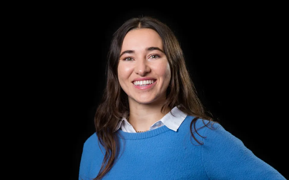 A headshot of Bianca Wilcox wearing a  a blue jumper over a blue shirt
