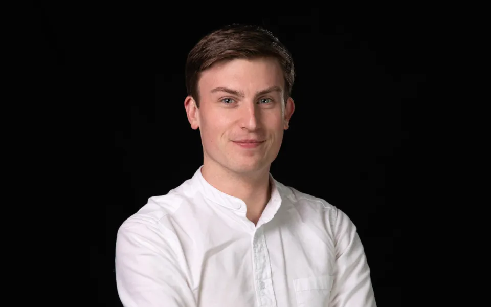 A headshot of David Montgomery wearing a white shirt