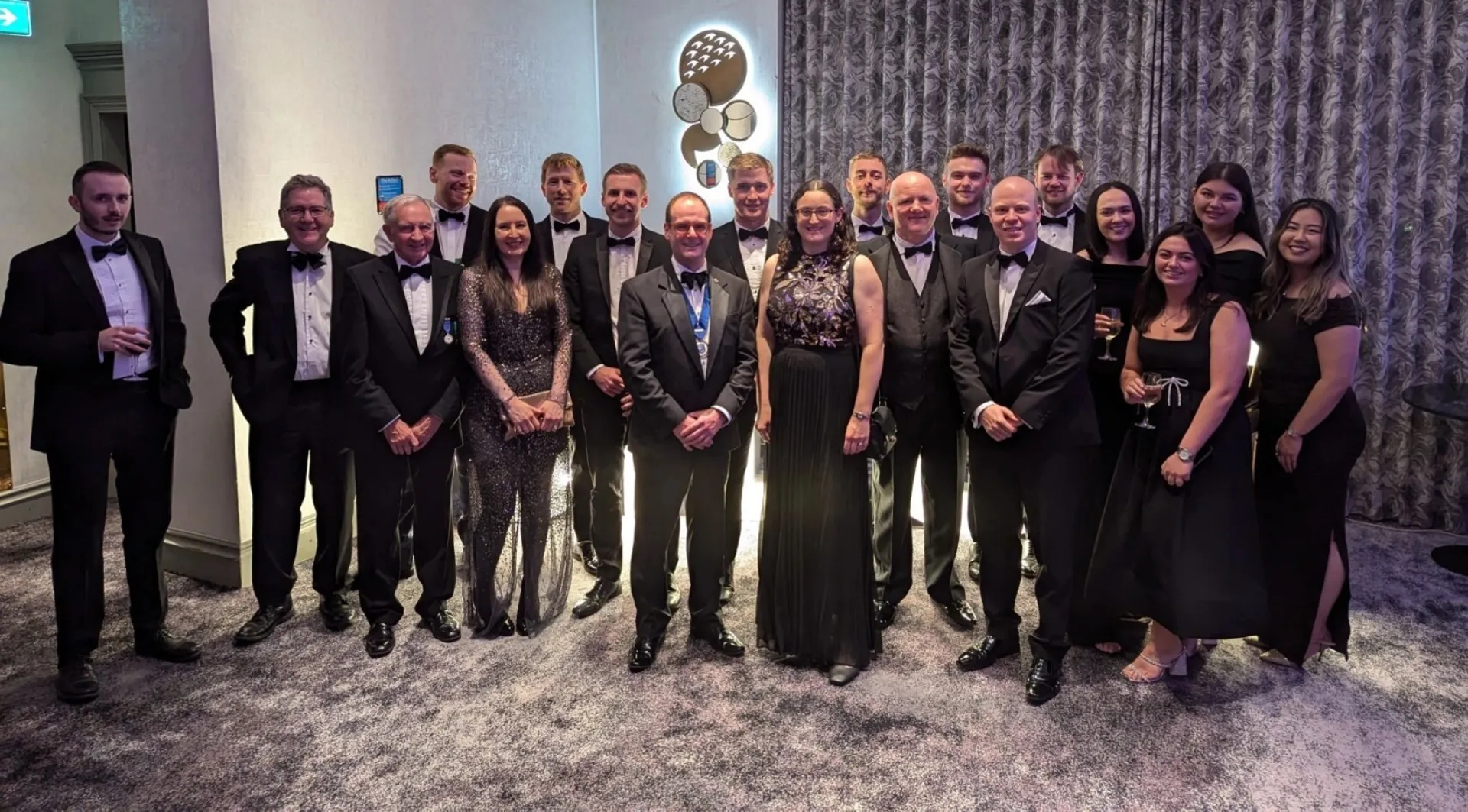 a group of people standing together in formal attire