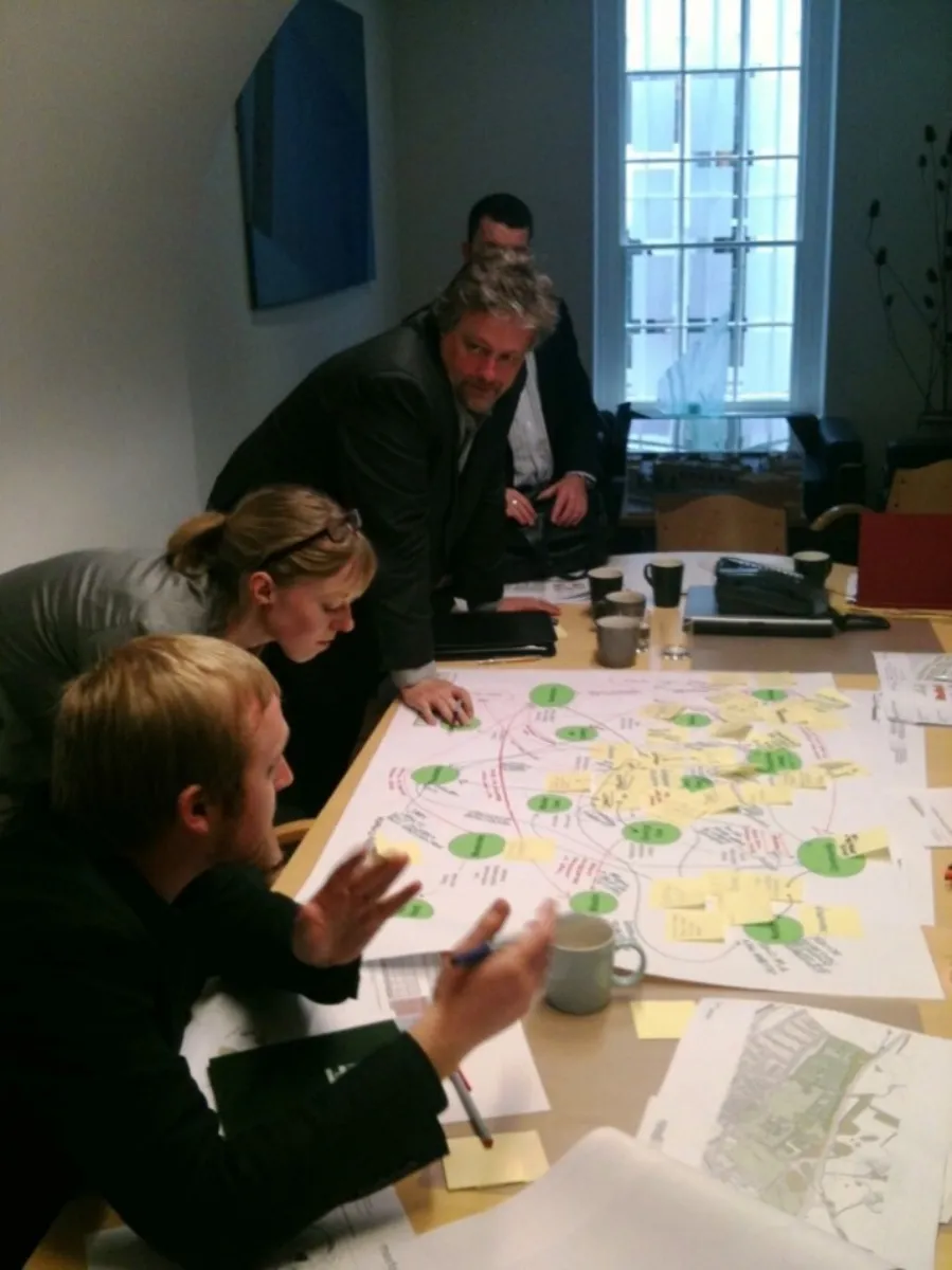 people gather around a table to discuss ideas.